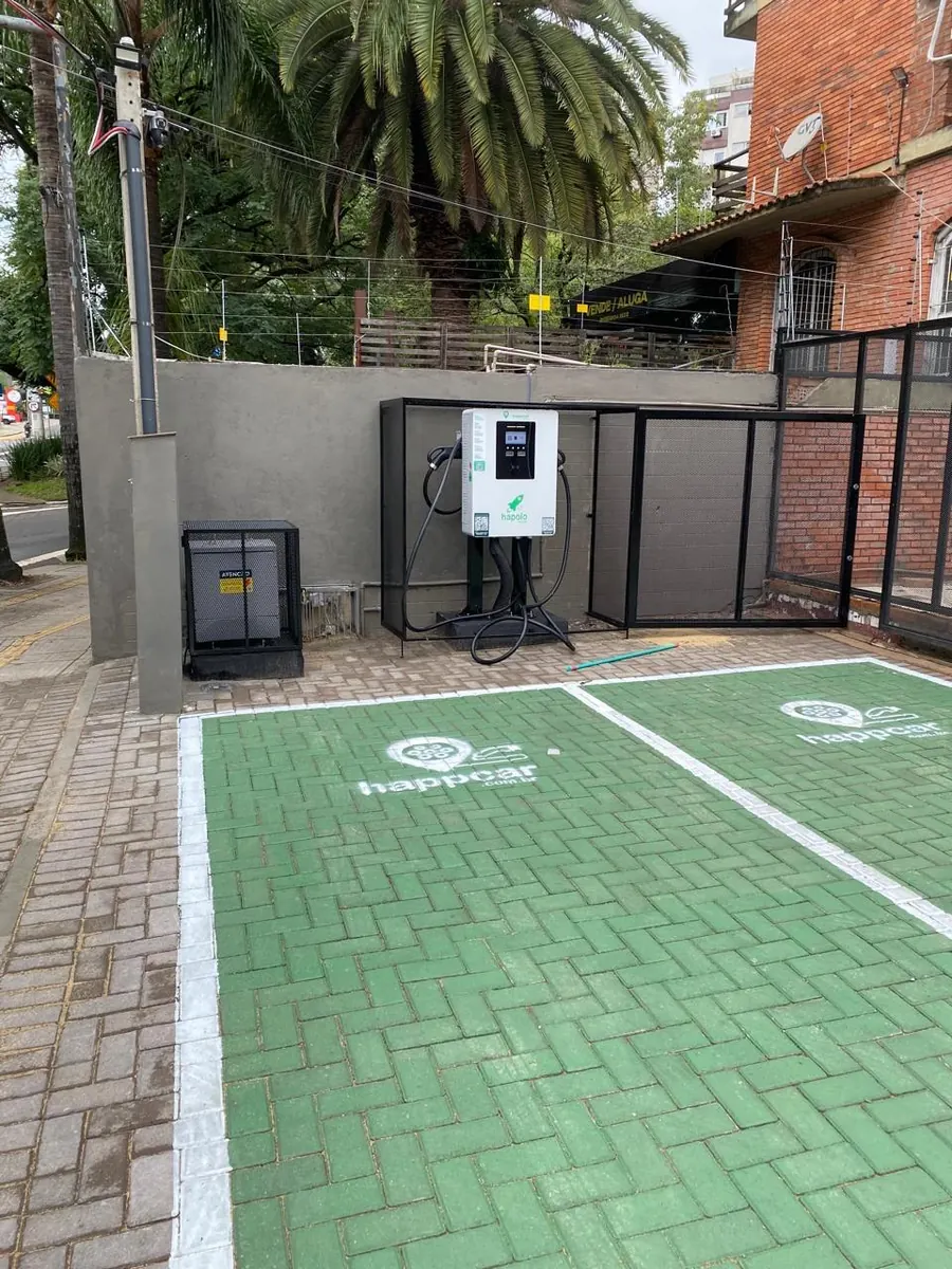 O Eletroposto Parcão na rua: o carregador rápido dentro da grade que o agente destrava, e as duas vagas demarcadas ao lado